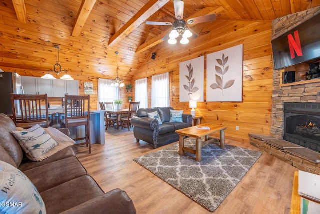 living room with wood ceiling, wood finished floors, wooden walls, and ceiling fan