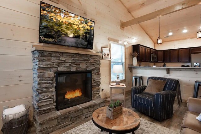 living room featuring a fireplace, light wood-type flooring, vaulted ceiling, and wood walls