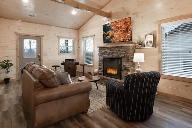 living room featuring a fireplace, vaulted ceiling with beams, hardwood / wood-style flooring, and wood walls