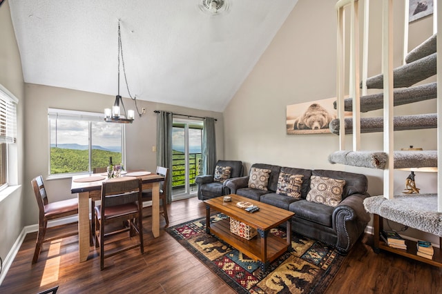 living room featuring a wealth of natural light, dark hardwood / wood-style flooring, high vaulted ceiling, and a chandelier