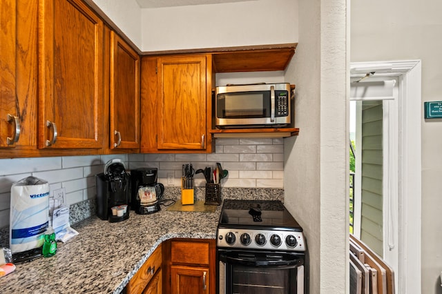 kitchen featuring dark stone countertops, decorative backsplash, and appliances with stainless steel finishes