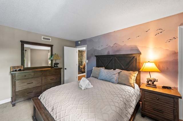 bedroom with a textured ceiling and light colored carpet