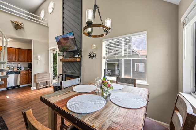 dining area with dark wood-type flooring and an inviting chandelier