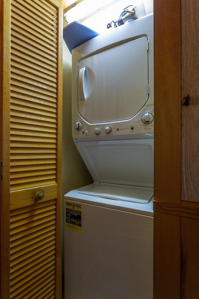 washroom featuring stacked washer / drying machine