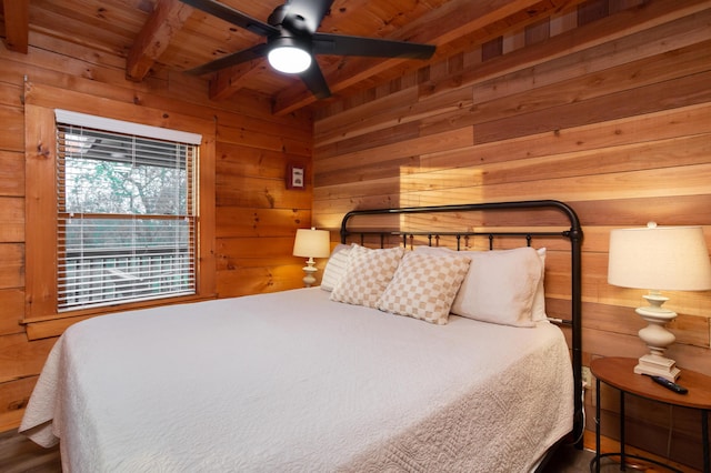 bedroom with beam ceiling, ceiling fan, wooden walls, and wood ceiling