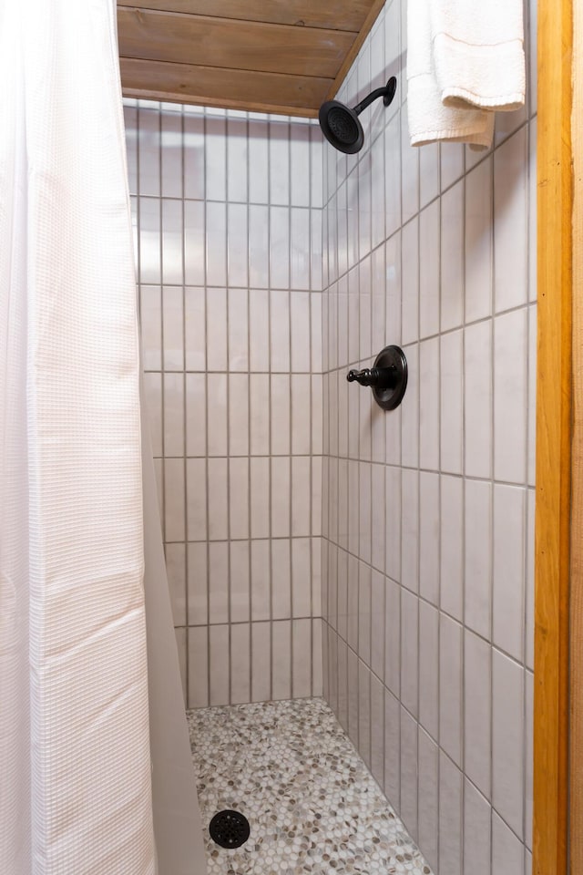 bathroom featuring a shower with shower curtain and wood ceiling