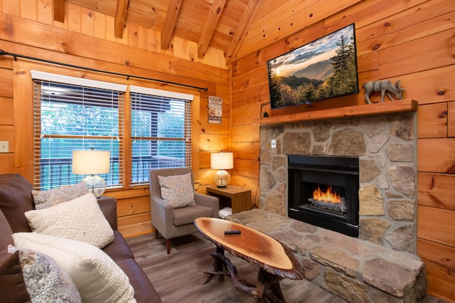 sitting room with a stone fireplace, lofted ceiling with beams, wood walls, wood ceiling, and hardwood / wood-style flooring