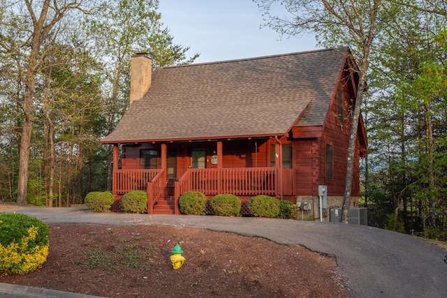 log home featuring a porch and cooling unit