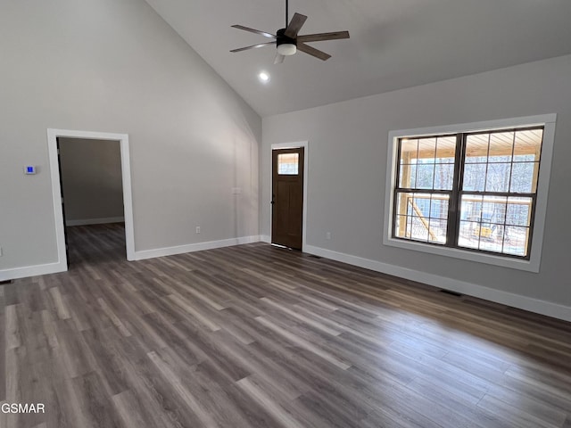 interior space with dark wood finished floors, baseboards, a wealth of natural light, and high vaulted ceiling