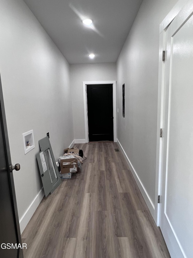 hallway featuring baseboards and dark wood-style flooring