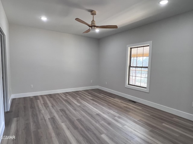 spare room with recessed lighting, ceiling fan, baseboards, and dark wood-style flooring