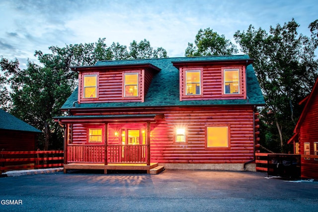 back of house with log exterior and roof with shingles