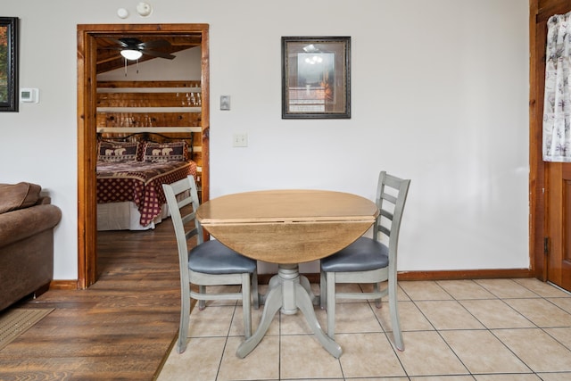 dining room with baseboards, lofted ceiling, ceiling fan, and light wood-style flooring