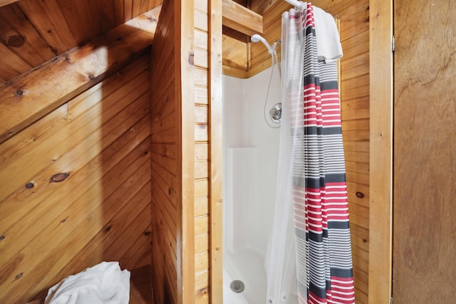 bathroom with wood walls, a stall shower, and wooden ceiling