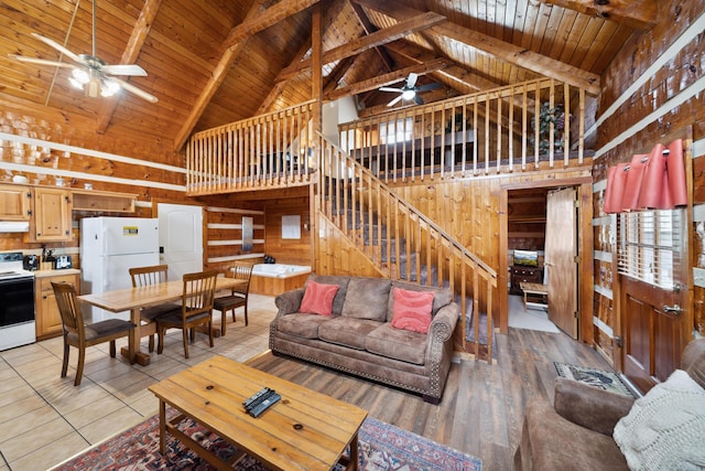 living room with wood walls, stairs, light tile patterned floors, wooden ceiling, and ceiling fan