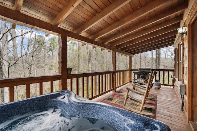 wooden terrace with area for grilling and a hot tub
