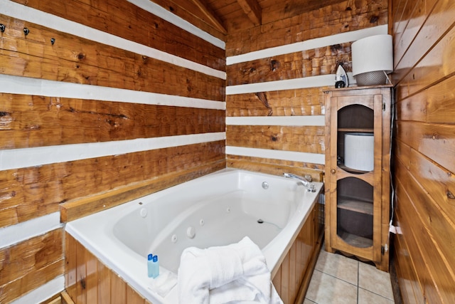 bathroom with tile patterned flooring, a whirlpool tub, wood walls, and lofted ceiling