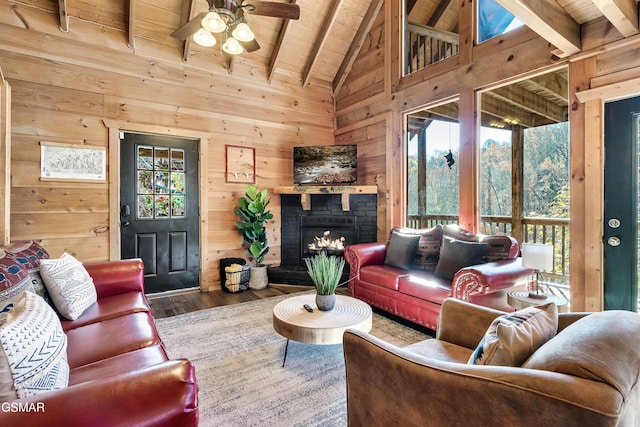 living room with wood walls, wood ceiling, a wealth of natural light, beamed ceiling, and hardwood / wood-style floors