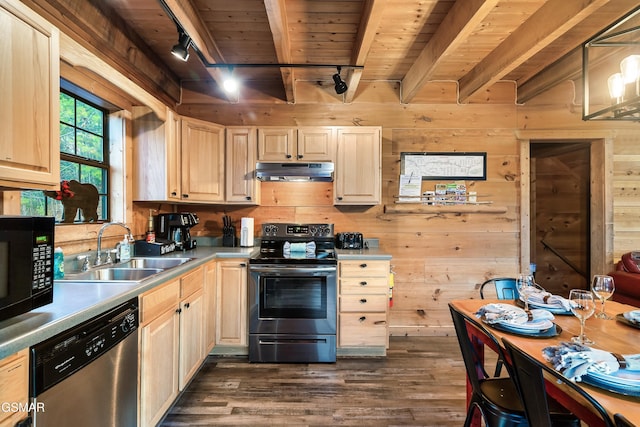 kitchen with sink, appliances with stainless steel finishes, track lighting, beamed ceiling, and wood walls