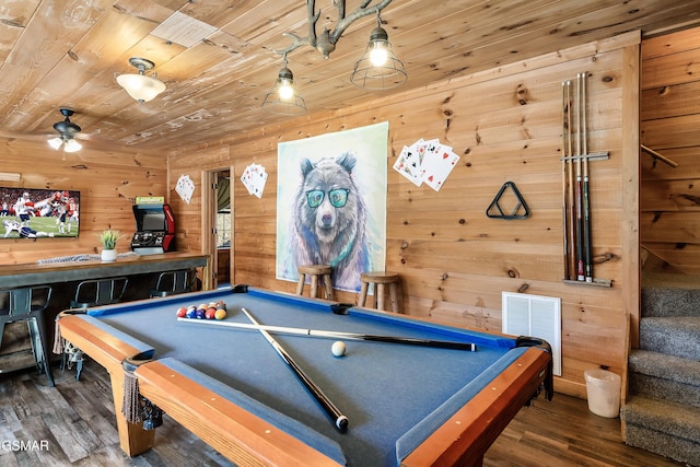 rec room with dark hardwood / wood-style flooring, wooden walls, and wooden ceiling