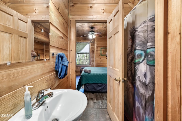 bathroom featuring sink, wood ceiling, and wood walls