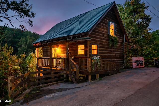 log-style house featuring a deck and covered porch