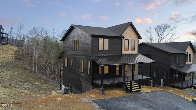 view of front of property with a porch and central air condition unit