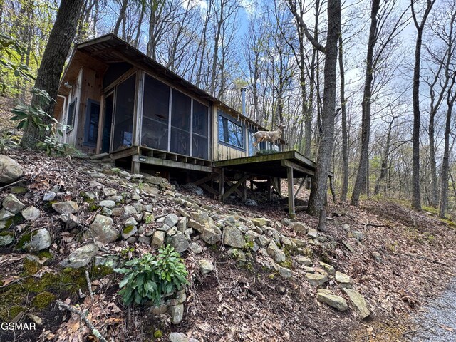 back of property featuring a deck and a sunroom