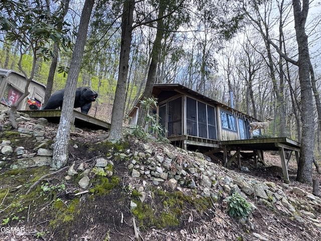 view of property exterior with a sunroom
