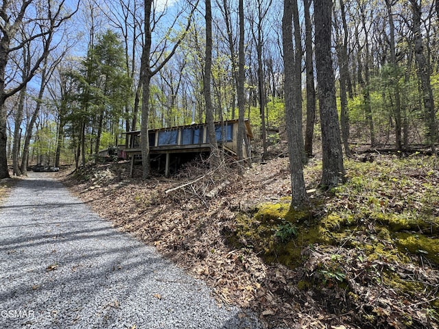 view of front of property with a deck and a wooded view