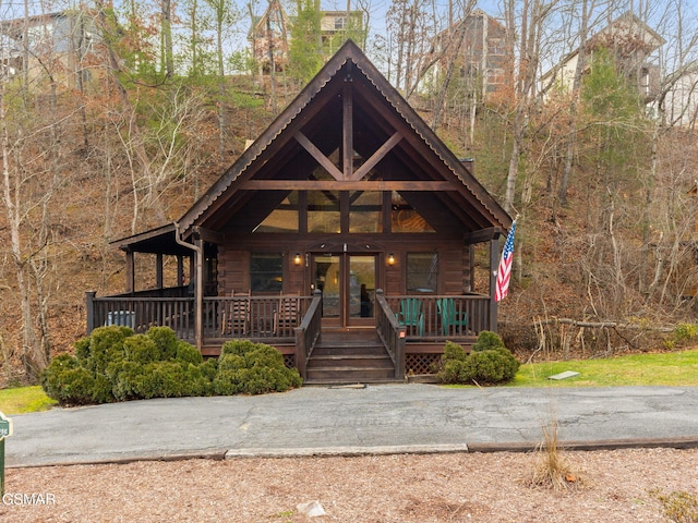 log-style house featuring covered porch