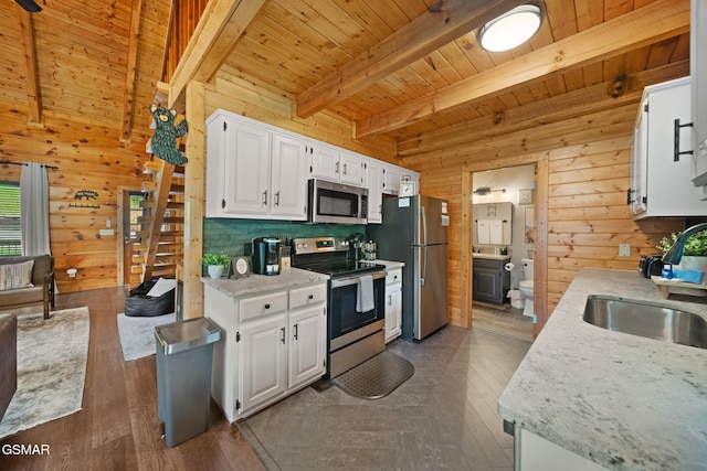 3955 Millers Ridge Way, Sevierville, TN 37862 - kitchen featuring stainless steel appliances, wooden walls, a wooden ceiling with exposed beams, dark wood-style floors, and white cabinetry