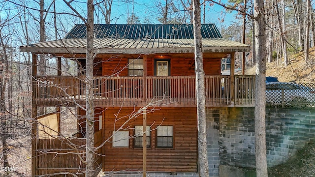 view of side of home with metal roof and faux log siding