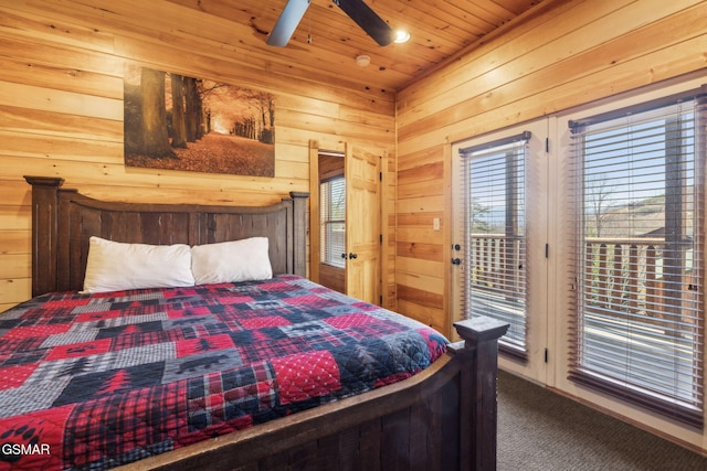 carpeted bedroom with access to exterior, wooden ceiling, and wood walls