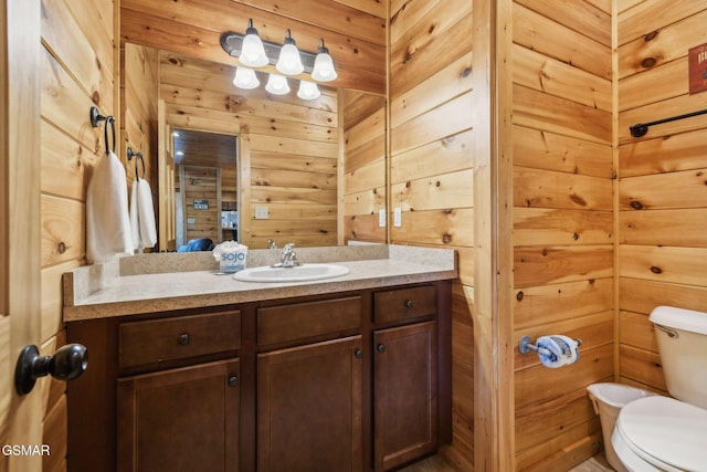 bathroom featuring wooden walls, vanity, and toilet