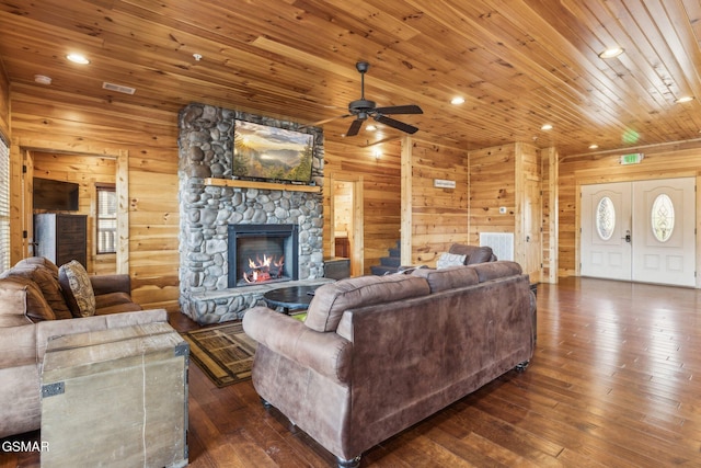 living room with wooden walls, dark wood-style floors, a fireplace, recessed lighting, and wood ceiling