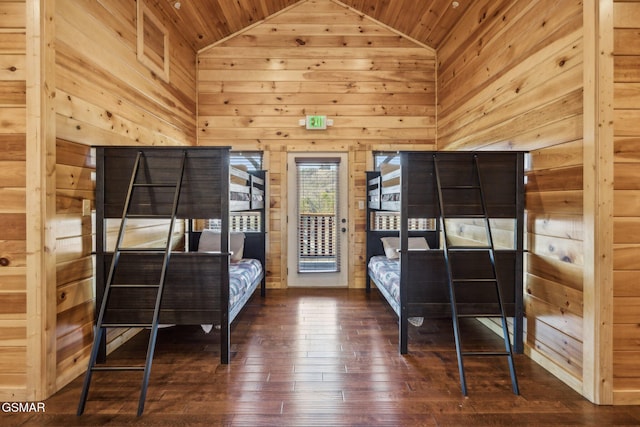 bedroom featuring access to exterior, wooden walls, wooden ceiling, and hardwood / wood-style floors