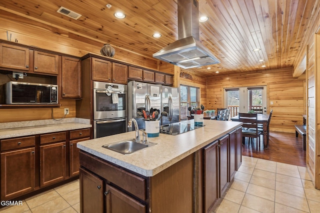 kitchen with visible vents, island exhaust hood, a sink, appliances with stainless steel finishes, and light tile patterned flooring