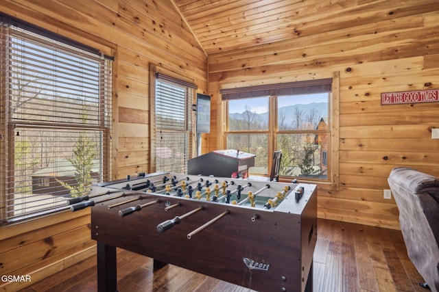 rec room with dark wood-type flooring, a mountain view, wood walls, wooden ceiling, and lofted ceiling