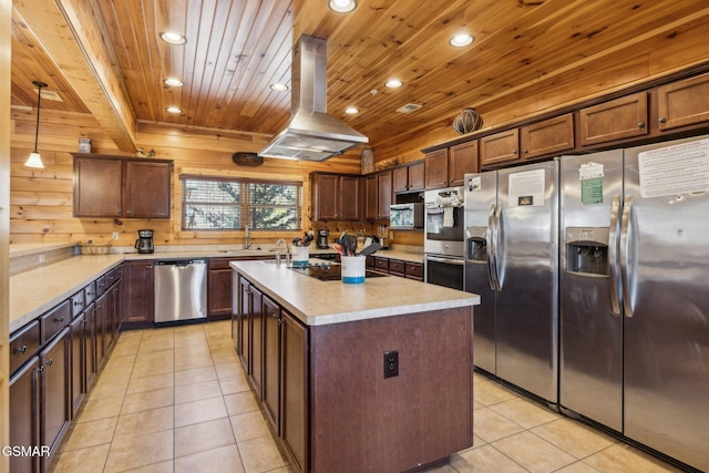 kitchen with light tile patterned floors, island exhaust hood, recessed lighting, stainless steel appliances, and light countertops