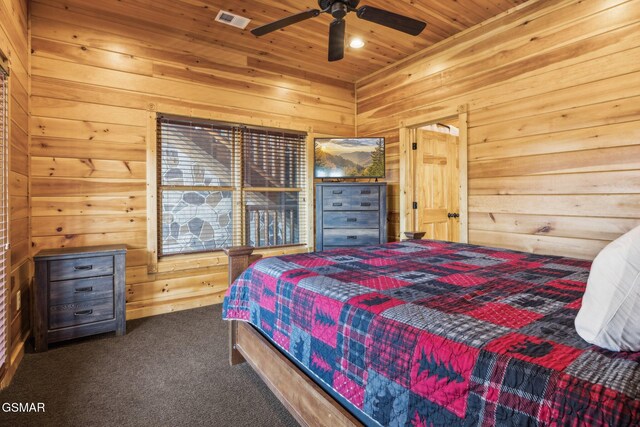 carpeted bedroom featuring ceiling fan, visible vents, wood walls, and wooden ceiling