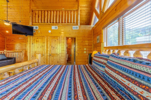 bedroom featuring a high ceiling and wooden walls