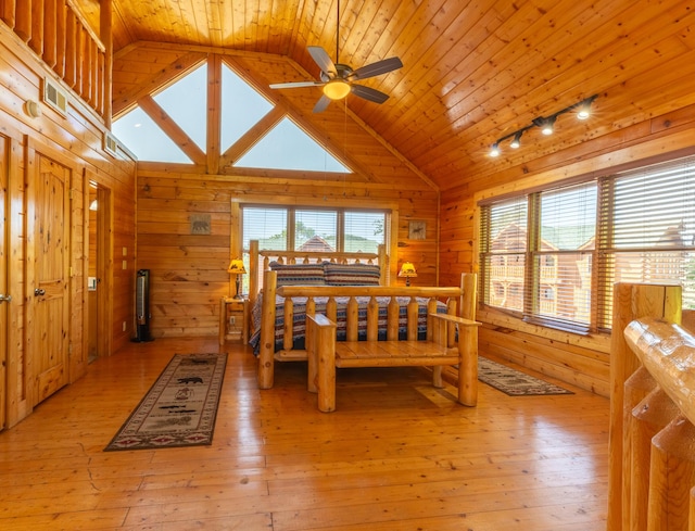 bedroom with wooden walls, wooden ceiling, vaulted ceiling, and light wood-type flooring