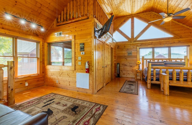 living room with ceiling fan, light hardwood / wood-style flooring, wood ceiling, and wood walls