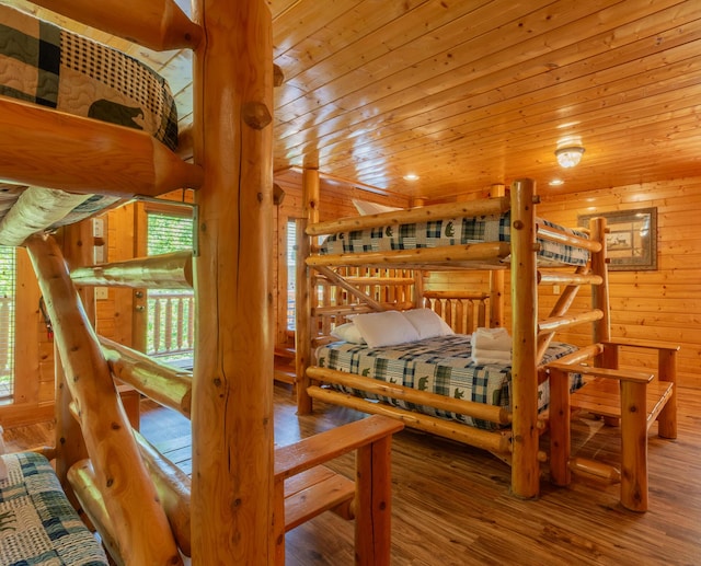 bedroom with hardwood / wood-style flooring, wooden ceiling, and wooden walls