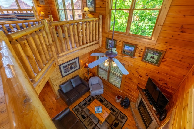 living room with ceiling fan and wood walls