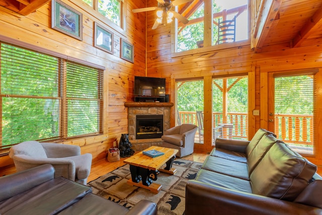 living room featuring hardwood / wood-style flooring, ceiling fan, and wood walls