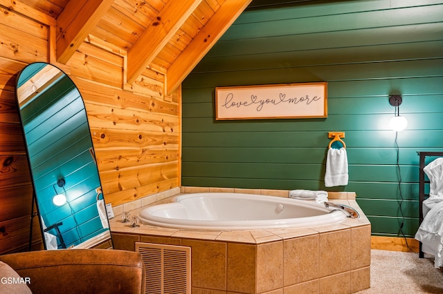 bathroom with a bath, visible vents, beamed ceiling, and wood walls