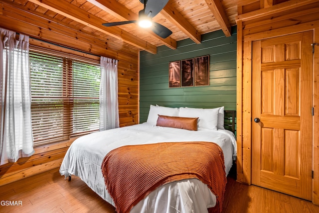 bedroom with wood finished floors, beamed ceiling, wood ceiling, and wood walls