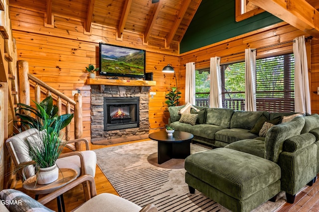 living room with stairway, wood finished floors, beam ceiling, wood walls, and wooden ceiling